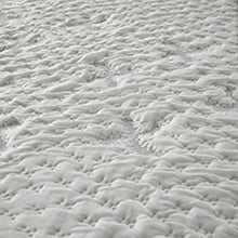 Close-up of the deep pebbled quilting on the Lay-Cell mattress, filled with mohair, cashmere, silk and wool