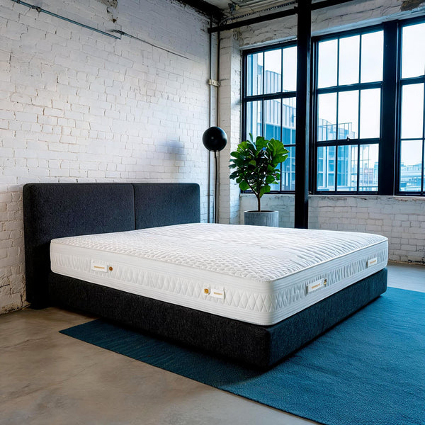 Carter & Lewis IceCool cooling mattress on a charcoal platform bed in a converted industrial loft bedroom