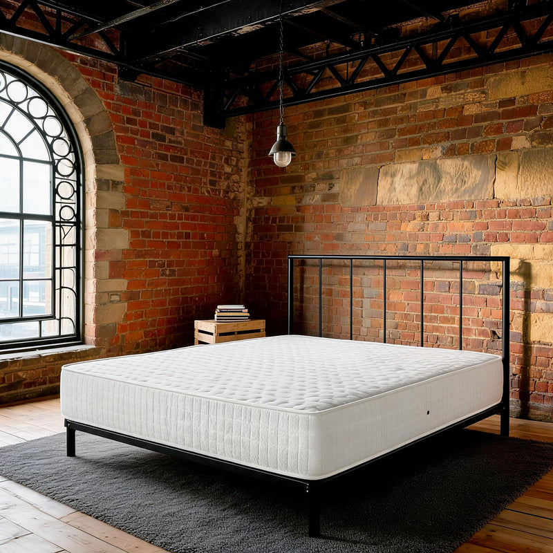 Carter & Lewis Rock extra firm 25cm foam mattress on a black steel bed in a converted mill brick bedroom